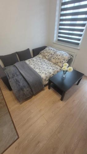 a bedroom with a bed and a table with flowers on it at Apartament "Cztery Pory Roku" in Świdnik
