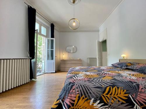 ein Schlafzimmer mit einem Bett mit einer bunten Bettdecke in der Unterkunft Le Varsovie ※ 4 balcons in Carcassonne