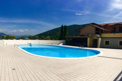 a large blue swimming pool in a tile yard at Copelia - Pool and Elegance in Paratico