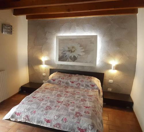 1 dormitorio con 1 cama con un cuadro de flores en la pared en Copelia - Pool and Elegance, en Paratico