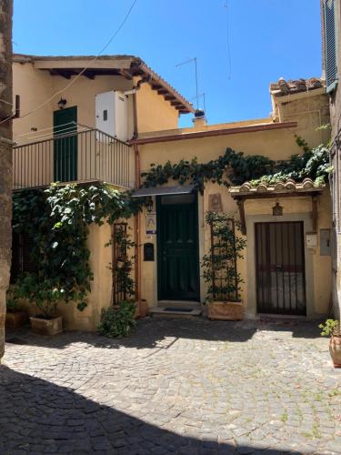 une maison avec une porte verte dans une cour dans l'établissement Platea Cavour, à Sutri