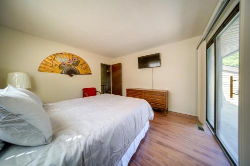 a bedroom with a white bed and a window at Cleveland Area Retreat Near Lake Erie in Richmond Heights
