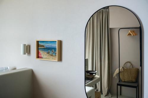 a mirror in a room with a picture of a beach at Euforia Retreat and Spa in Eforie Nord