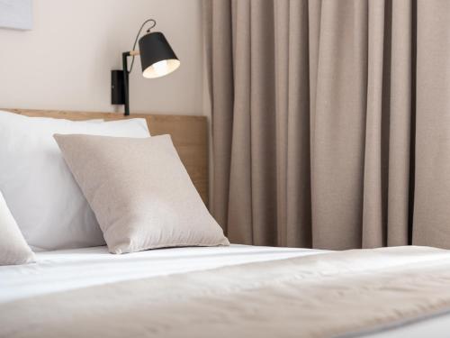 a bedroom with a bed with a pillow and a curtain at Calives Premium Stay in Kalyves Poligirou