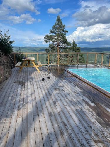 una terraza de madera con piscina y un árbol en Brand new mountain cabin, en Branäs