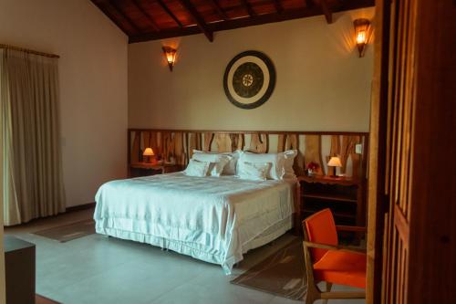 a bedroom with a bed and a clock on the wall at Illuminare Stile in Fortim