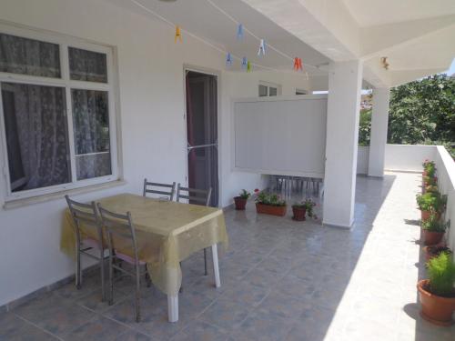 a white house with a table and a screen at Elite Apart Pansiyon in Gokceada Town