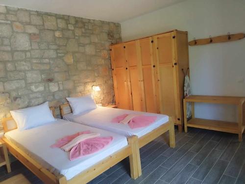 two beds in a room with a stone wall at Tropical Garden Prime Accommodation in Faliraki