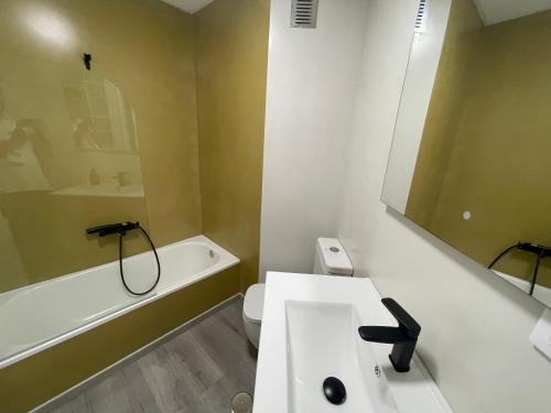 a bathroom with a sink and a tub and a toilet at LA Lujuria in Ourense