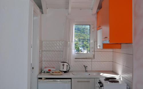 a small kitchen with a sink and a window at Studios Soula in Alonnisos