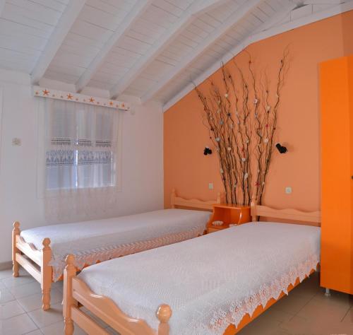 two beds in a room with a window at Studios Soula in Alonnisos