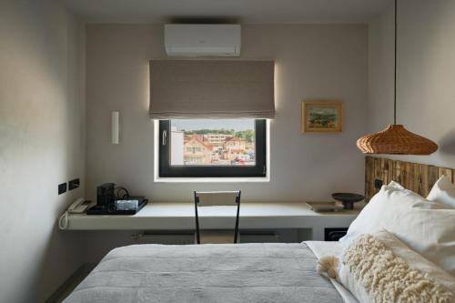 a bedroom with a bed and a desk with a window at Euforia Retreat and Spa in Eforie Nord