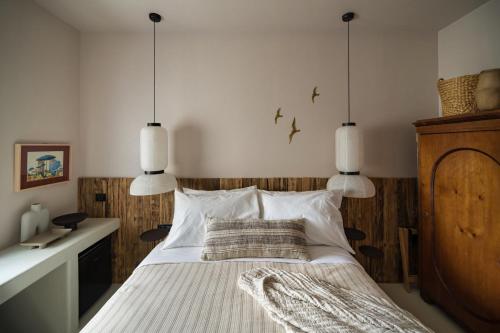 a bedroom with a bed with white sheets and pillows at Euforia Retreat and Spa in Eforie Nord