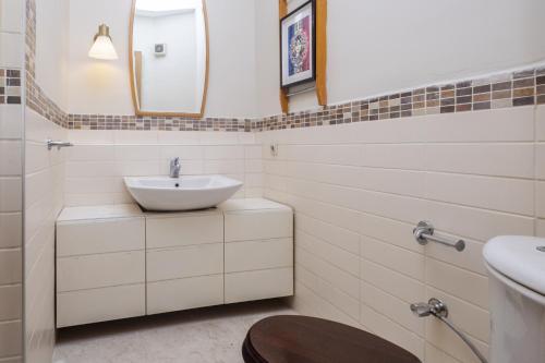 ein weißes Badezimmer mit einem Waschbecken und einem Spiegel in der Unterkunft Apartment wit in Istanbul