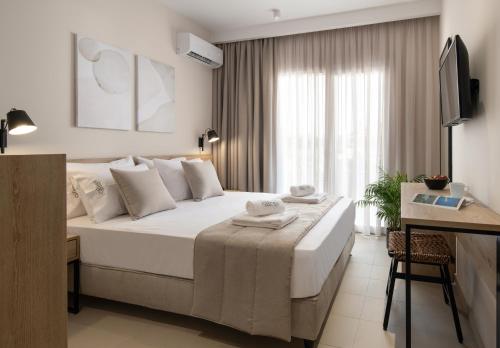 a hotel room with a bed and a desk and a bed sidx sidx sidx sidx at Calives Premium Stay in Kalyves Poligirou