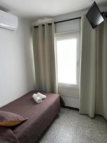 a bedroom with a bed with two towels on it at L'Illa Hotel in Tossa de Mar