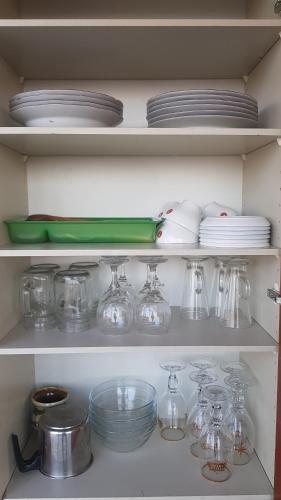 a refrigerator shelf filled with glass dishes and plates at Briza Marii in Costinesti