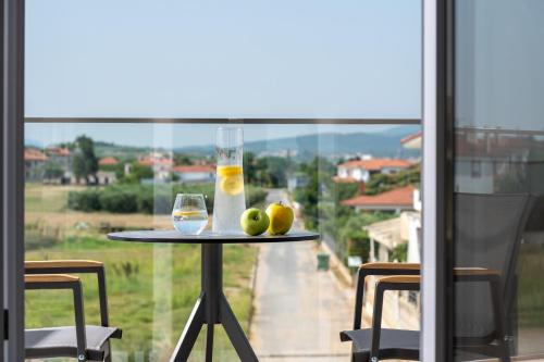 a table with a glass of wine and fruit on it at Calives Premium Stay in Kalyves Poligirou