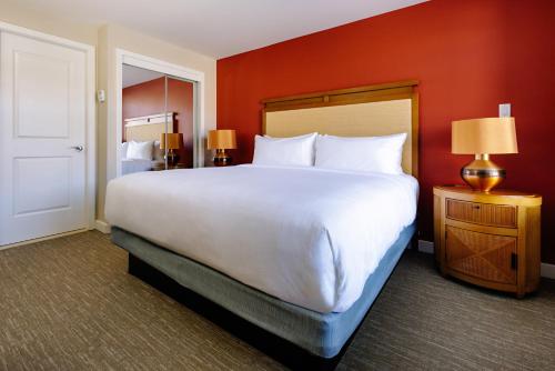 a large white bed in a hotel room with red walls at Watermark Beach Resort in Osoyoos