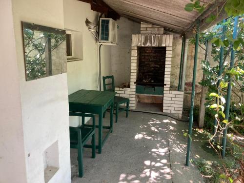 a patio with a green table and chairs in a house at Apartman K 99, Karadjordjeva 99, Bela Crkva in Bela Crkva