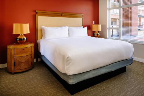 a bedroom with a large white bed and two lamps at Watermark Beach Resort in Osoyoos