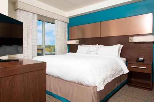 - une chambre avec un grand lit et une télévision à écran plat dans l'établissement Residence Inn by Marriott Ann Arbor Downtown, à Ann Arbor