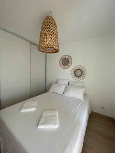 - une chambre avec un lit blanc et un lustre dans l'établissement T3 Bohème au cœur de Port Marianne, à Montpellier