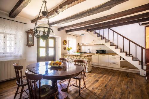 a kitchen and dining room with a table and a staircase at Casa Rustica 1838 in Sovinjak