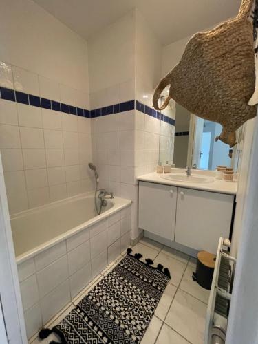 une salle de bain avec une baignoire et un lavabo et une baignoire dans l'établissement T3 Bohème au cœur de Port Marianne, à Montpellier