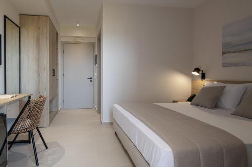 a bedroom with a large bed and a desk and a desk at Calives Premium Stay in Kalyves Poligirou