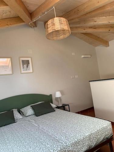 una camera con letto verde e soffitto di The house in the alley a Casella