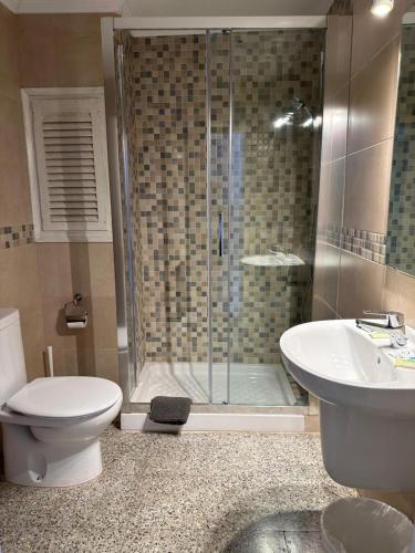 a bathroom with a shower and a toilet and a sink at L'Illa Hotel in Tossa de Mar