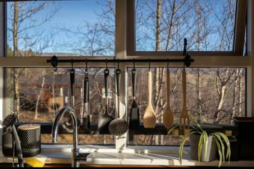 a kitchen with utensils hanging from a window at Traditional Cottage with Jacuzzi and Lake View Laugarvatn, Árnessýsla, Islandia in Laugarvatn