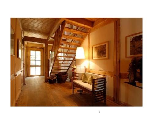 a living room with a staircase and a couch at Hotel Haferland in Wieck
