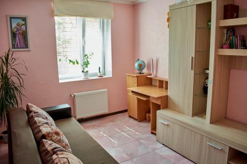 ein Wohnzimmer mit rosa Wänden und einem Sofa in der Unterkunft Vacation home Lubov in Kamjanez-Podilskyj