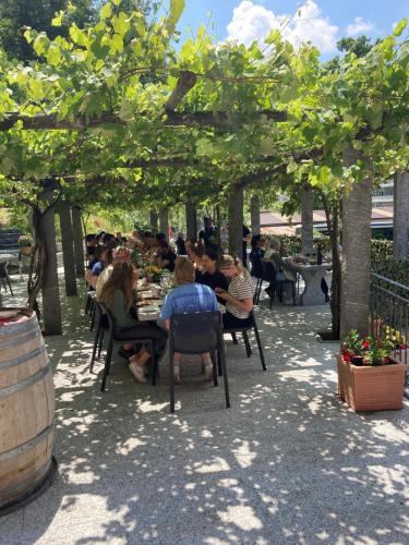a group of people sitting at tables under a pergola at Hotel Ristorante Grotto Serta in Lamone