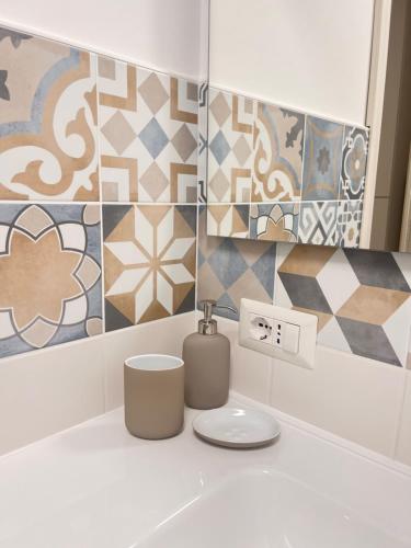 a bathroom with tiles on the wall and a sink at City Home 77 in Naples