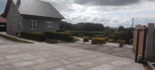 una casa con vialetto in pietra accanto a un giardino di Toxiños Lavacolla ad A Coruña