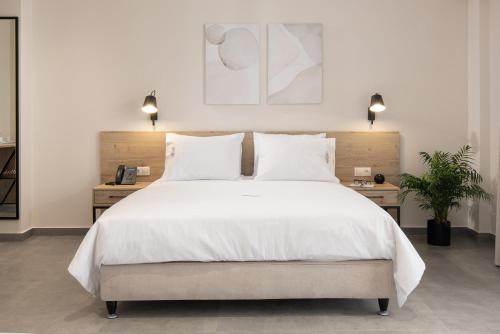 a bedroom with a large white bed with two night stands at Calives Premium Stay in Kalyves Poligirou