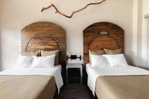 dos camas sentadas una al lado de la otra en una habitación en Hotel Rocaval San Cristóbal de las Casas en San Cristóbal de Las Casas