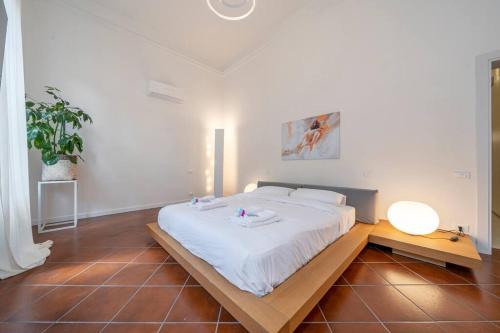 a bedroom with a large white bed and a table at PALAZZO DUCALE - Romantico appartamento in centro in Modena