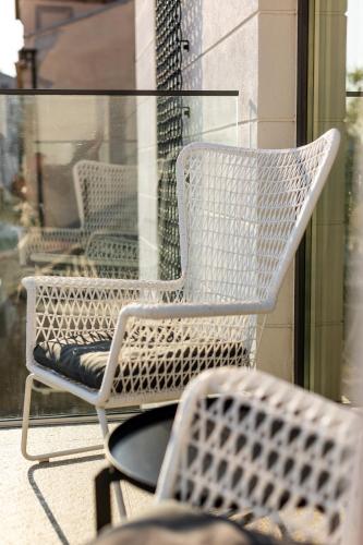 a white wicker chair sitting on a patio at Rosetti One in Constanţa