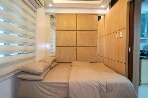 een klein bed in een kamer met een raam bij A2J Executive Studio Near Venice Mall BGC Taguig in Manilla
