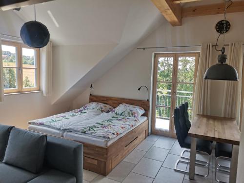 1 dormitorio con cama, sofá y mesa en Ferienwohnung Meyer o, en Weissenburg in Bayern