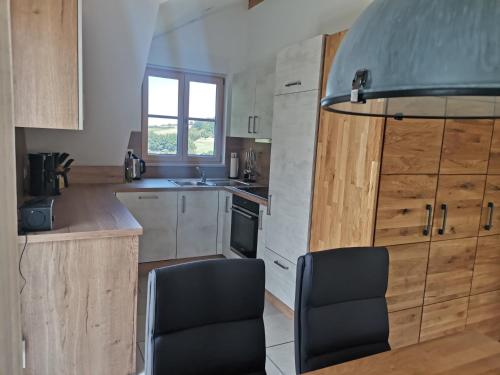 a kitchen with a table and two chairs in it at Ferienwohnung Meyer Obergeschoss in Weißenburg in Bayern