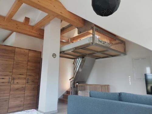 a living room with a staircase and a blue couch at Ferienwohnung Meyer Obergeschoss in Weißenburg in Bayern