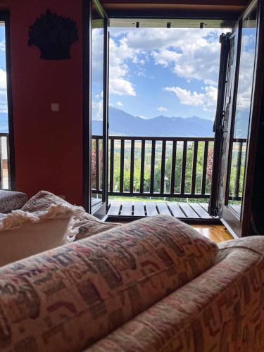 a bedroom with a large window with a view of a balcony at Casa Elegancia, Pleta de Saga in Ger