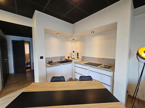 a kitchen with white cabinets and a table and chairs at Aérogites Chambley in Dommartin-la-Chapelle