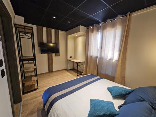 a bedroom with a bed with blue pillows at Aérogites Chambley in Dommartin-la-Chapelle