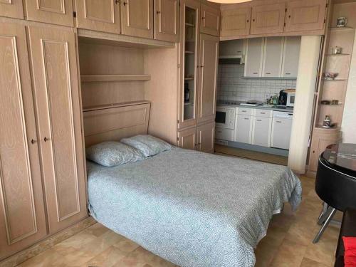 une petite chambre avec un lit et une cuisine dans l'établissement La Potinière studio face Mer, à Le Touquet-Paris-Plage